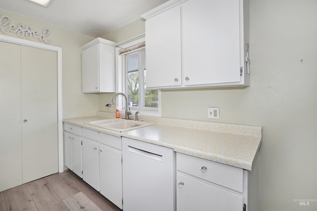 kitchen featuring white cabinets, a sink, light wood finished floors, and light countertops