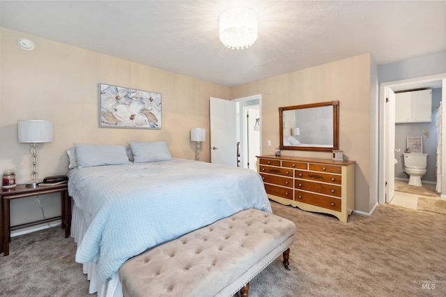 carpeted bedroom featuring ensuite bath