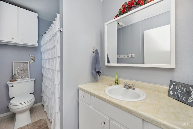 bathroom featuring vanity, tile patterned floors, baseboards, and toilet