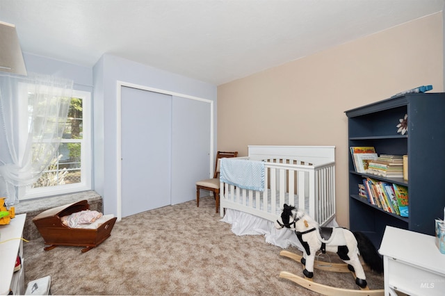 carpeted bedroom with a closet and a nursery area