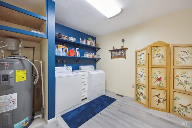 laundry room featuring washing machine and clothes dryer, laundry area, light wood-type flooring, visible vents, and electric water heater