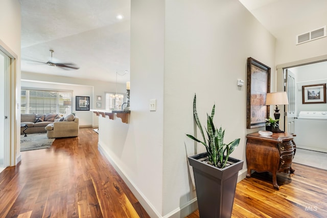 hallway with washer / clothes dryer and hardwood / wood-style floors