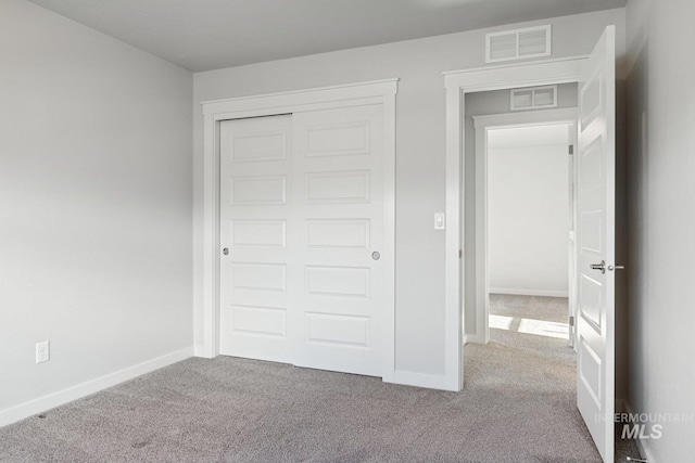 unfurnished bedroom featuring a closet and light carpet