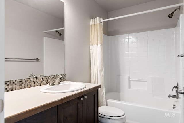 full bathroom featuring shower / bath combo with shower curtain, toilet, vanity, and tasteful backsplash