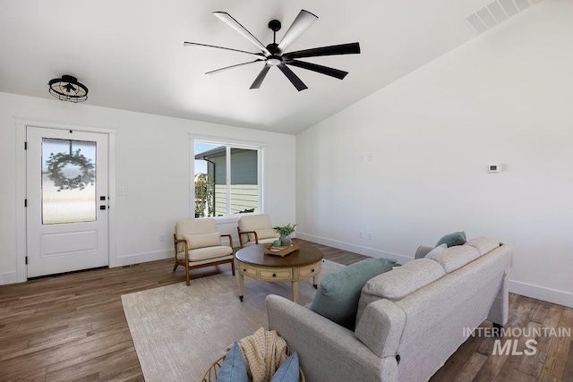 living room featuring ceiling fan, vaulted ceiling, and wood-type flooring