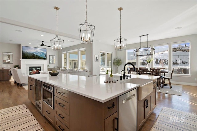 kitchen featuring open floor plan, stainless steel appliances, light countertops, and decorative light fixtures