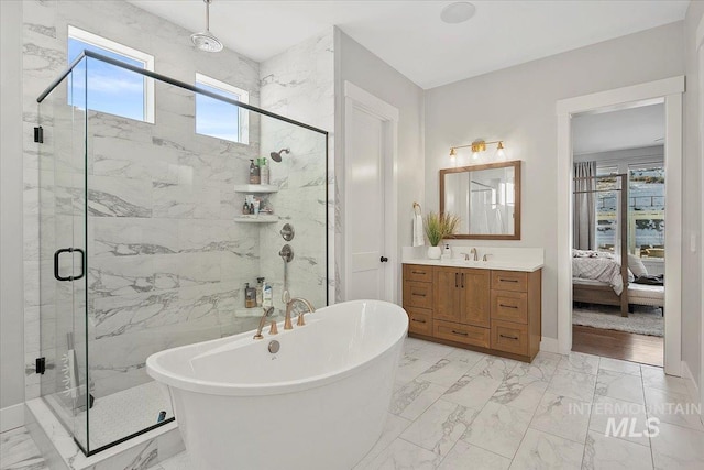 bathroom featuring ensuite bathroom, a freestanding tub, vanity, marble finish floor, and a marble finish shower