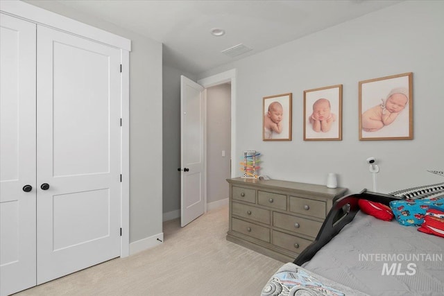 bedroom featuring baseboards, visible vents, and a closet