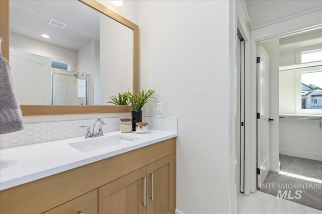 375 N Sauer River Ln, Eagle, ID 83616 - bathroom with vanity, baseboards, a shower with door, and tasteful backsplash