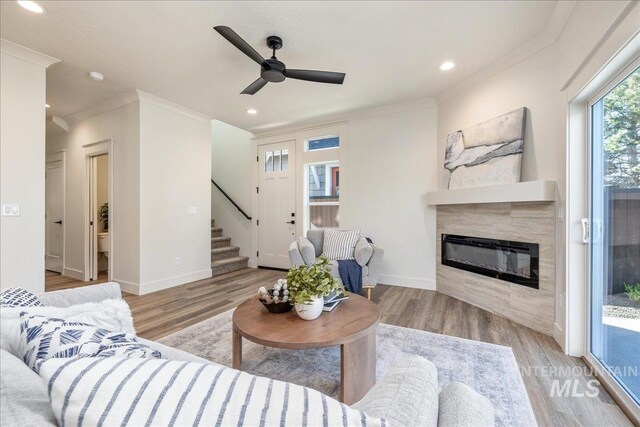 375 N Sauer River Ln, Eagle, ID 83616 - living room with stairway, a glass covered fireplace, crown molding, wood finished floors, and a ceiling fan