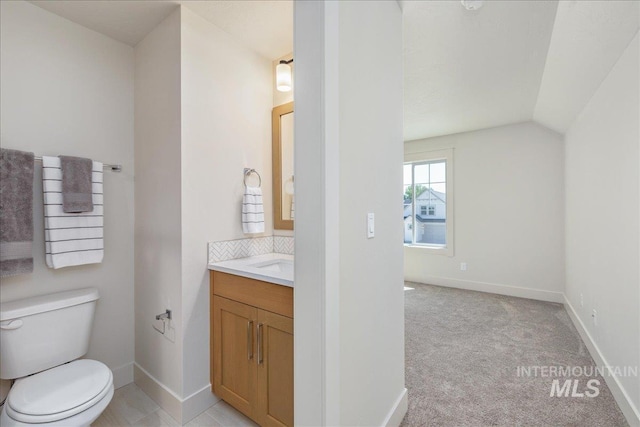 375 N Sauer River Ln, Eagle, ID 83616 - bathroom with toilet, vanity, lofted ceiling, baseboards, and decorative backsplash