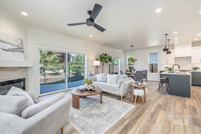 375 N Sauer River Ln, Eagle, ID 83616 - living area with light wood-style flooring, a ceiling fan, crown molding, a fireplace, and recessed lighting