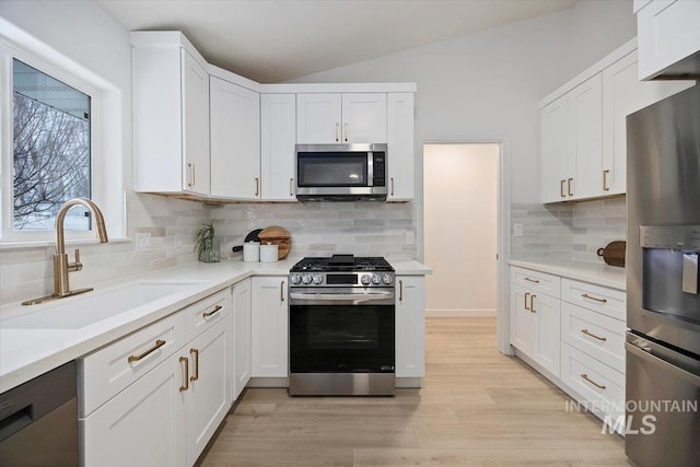 kitchen featuring a sink, white cabinets, stainless steel appliances, and light countertops