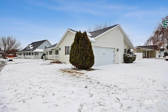 view of snowy exterior featuring a garage