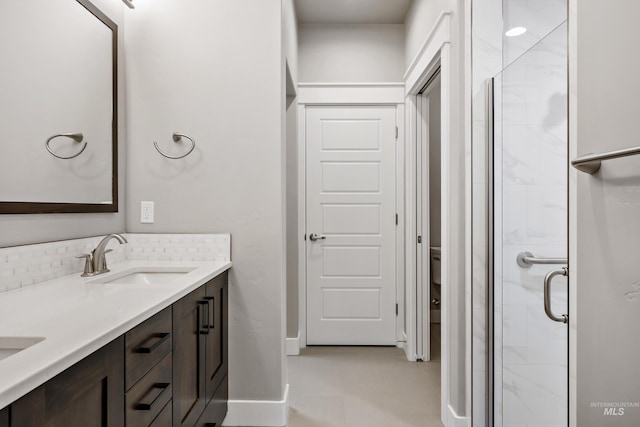 bathroom featuring tile patterned flooring, vanity, toilet, and walk in shower