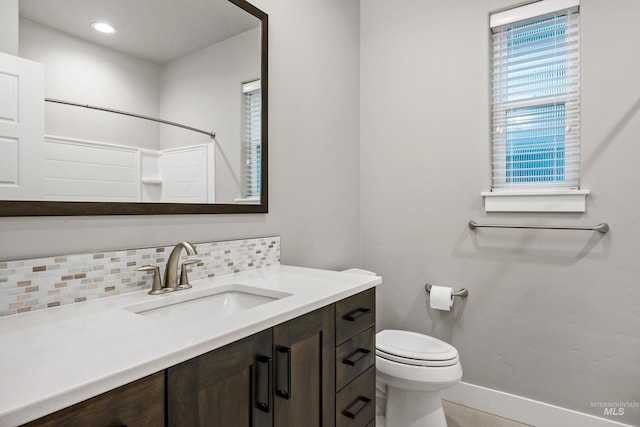 bathroom with decorative backsplash, vanity, and toilet