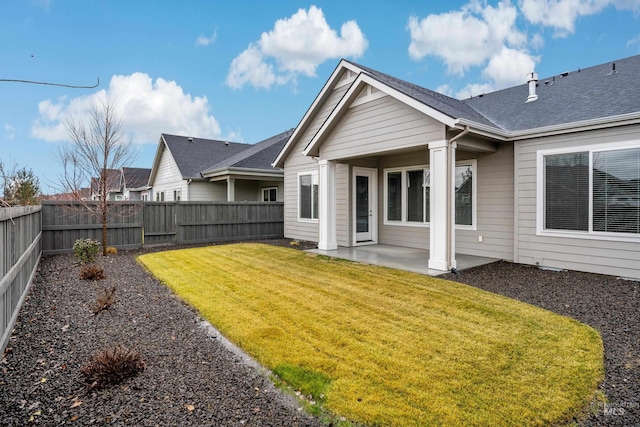 back of house with a patio area and a lawn