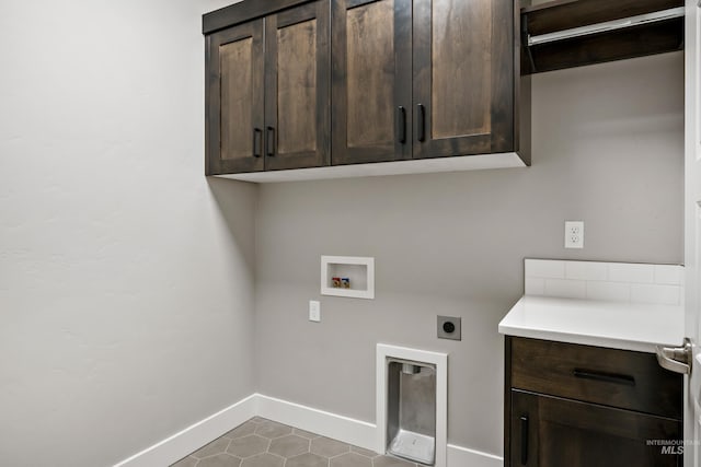 clothes washing area featuring dark tile patterned flooring, electric dryer hookup, cabinets, and hookup for a washing machine