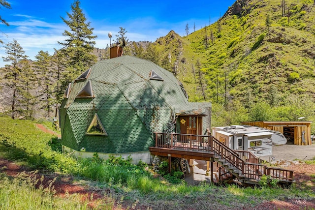 rear view of property with a deck with mountain view