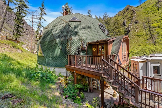 rear view of house with a deck with mountain view