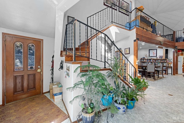 entryway featuring tile patterned floors and a high ceiling