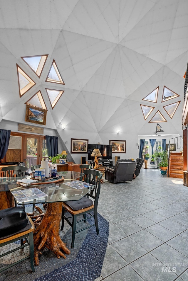 dining area featuring a high ceiling and tile patterned floors