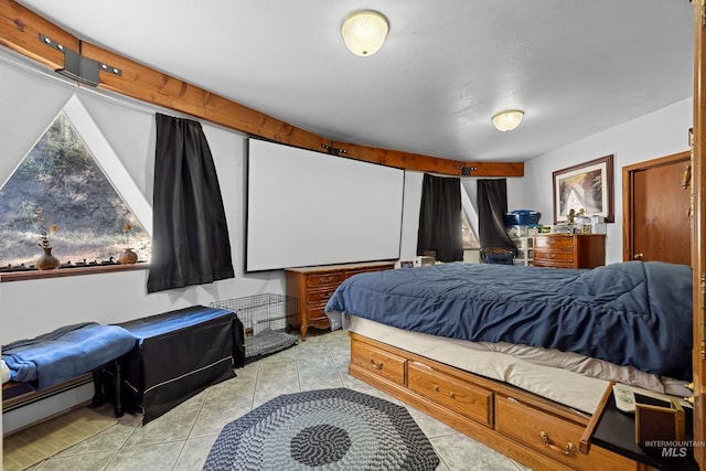 bedroom with a baseboard heating unit and light tile patterned flooring