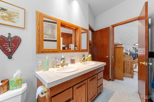 bathroom featuring toilet, vanity, and decorative backsplash