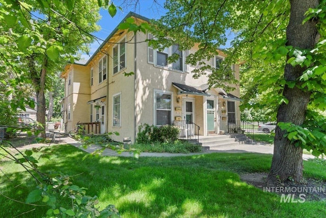 multi unit property with stucco siding and fence