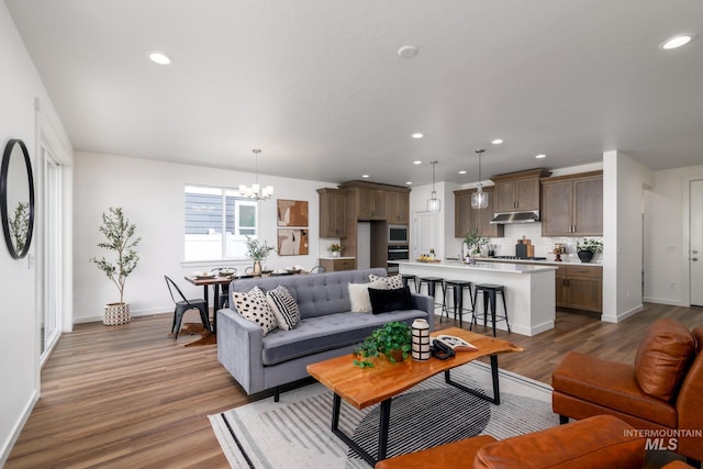 living room featuring a chandelier and light hardwood / wood-style floors