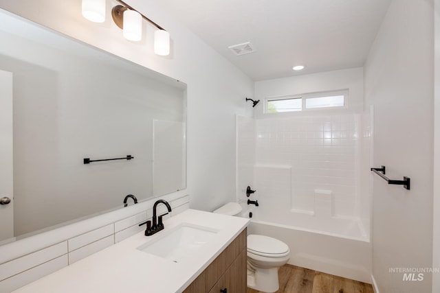 full bathroom with toilet, hardwood / wood-style flooring, vanity, and bathing tub / shower combination