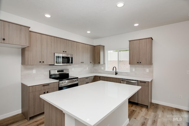 kitchen featuring light hardwood / wood-style floors, a center island, tasteful backsplash, and stainless steel appliances