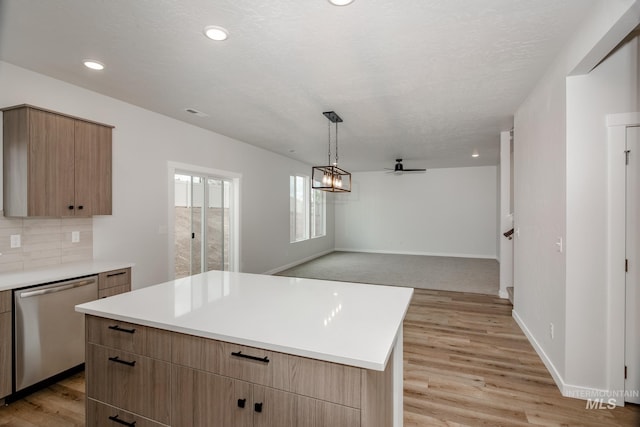 kitchen featuring stainless steel dishwasher, decorative light fixtures, a center island, and light wood-type flooring