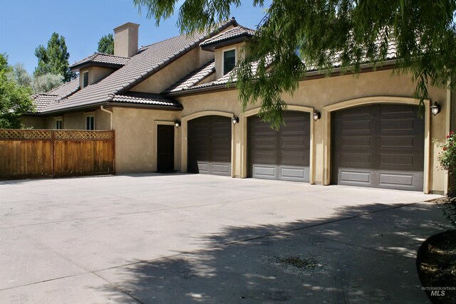 3349 E 4050 N, Twin Falls, ID 83301 - view of front of property with concrete driveway, a chimney, a tiled roof, stucco siding, and a garage