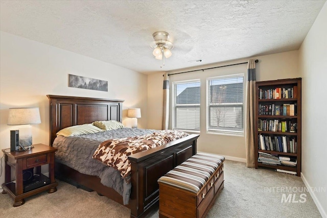 carpeted bedroom featuring ceiling fan and a textured ceiling