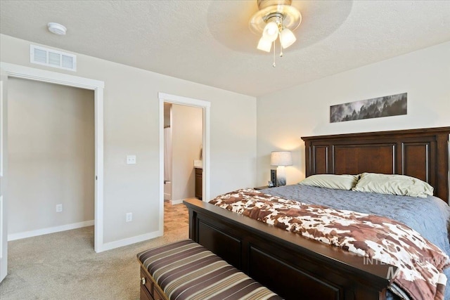 bedroom featuring ceiling fan, a textured ceiling, and light colored carpet