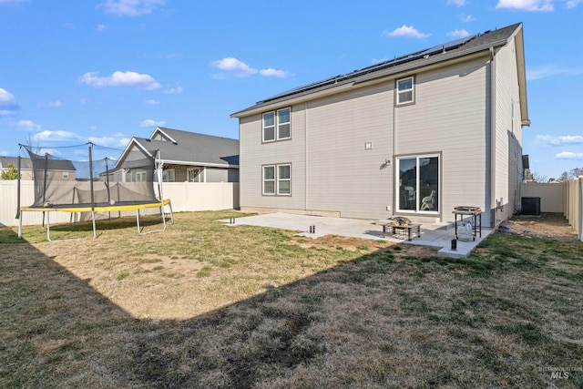 3749 E Rock Falls St, Nampa, ID 83686 - back of house with a fenced backyard, a patio area, a trampoline, and a lawn
