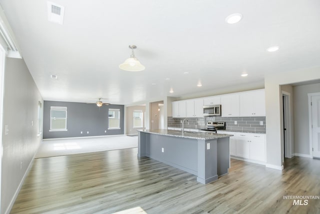 3749 E Rock Falls St, Nampa, ID 83686 - kitchen with visible vents, light wood finished floors, baseboards, and stainless steel appliances