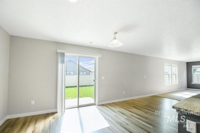 3749 E Rock Falls St, Nampa, ID 83686 - unfurnished living room with wood finished floors, visible vents, and baseboards