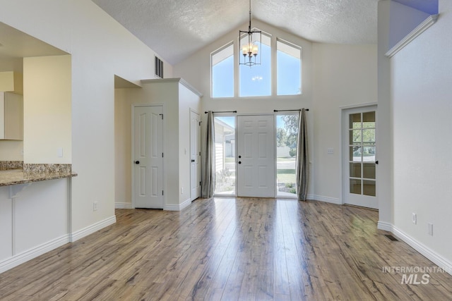 12335 W Red Spruce, Boise, ID 83713 - foyer with a chandelier, wood finished floors, high vaulted ceiling, and a textured ceiling