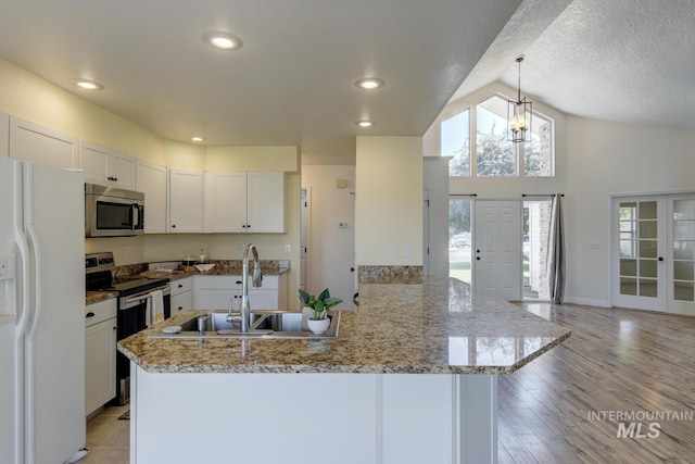 12335 W Red Spruce, Boise, ID 83713 - kitchen featuring stainless steel appliances, vaulted ceiling, white cabinetry, light stone countertops, and decorative light fixtures