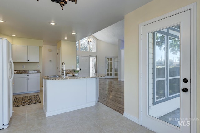 12335 W Red Spruce, Boise, ID 83713 - kitchen with white fridge with ice dispenser, plenty of natural light, light stone countertops, white cabinets, and recessed lighting