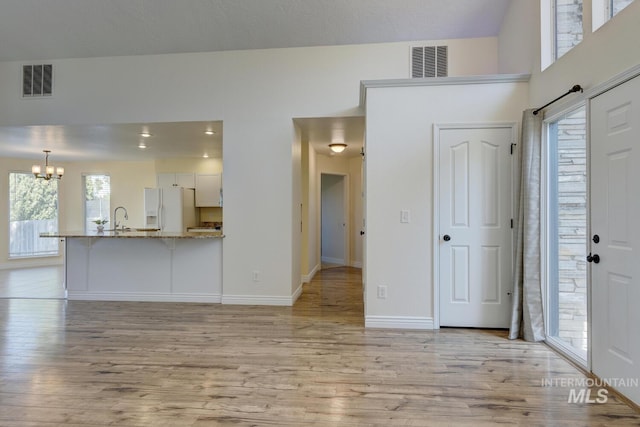 12335 W Red Spruce, Boise, ID 83713 - unfurnished living room featuring a chandelier and light wood-type flooring