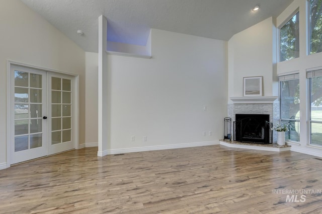 12335 W Red Spruce, Boise, ID 83713 - unfurnished living room with plenty of natural light, wood finished floors, a fireplace with raised hearth, and high vaulted ceiling