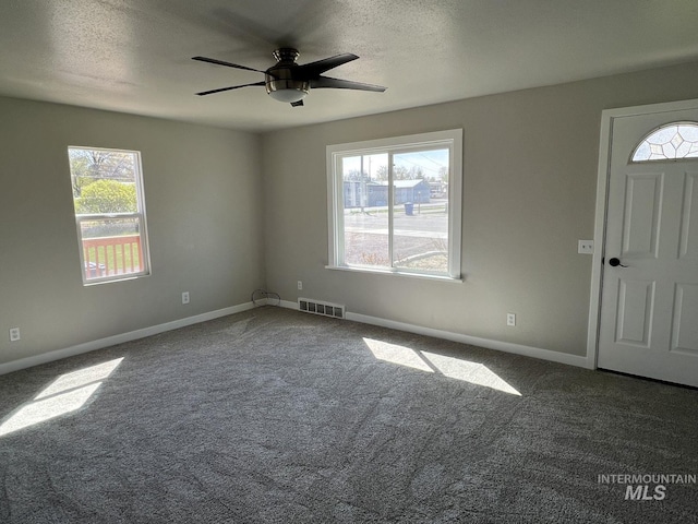 foyer entrance featuring visible vents, baseboards, a ceiling fan, and carpet floors