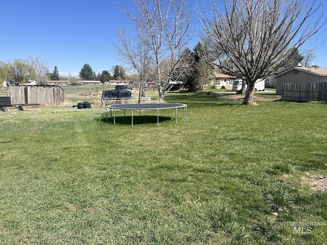 view of yard with fence and a trampoline