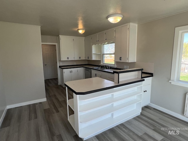 kitchen featuring white cabinets, dishwashing machine, open shelves, and wood finished floors