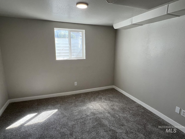 carpeted empty room featuring baseboards