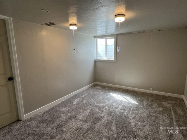 below grade area featuring visible vents, baseboards, and carpet flooring