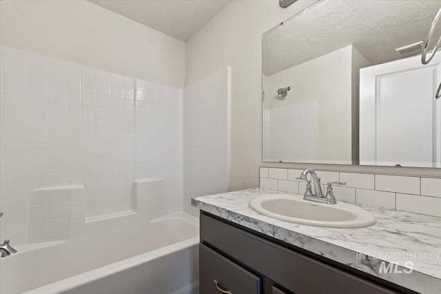 2312 E Spice Loop Unit 3, Nampa, ID 83687 - bathroom featuring vanity, tub / shower combination, and a textured ceiling